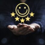Businessman holding smile icon for the best evaluation , customer satisfaction concept.